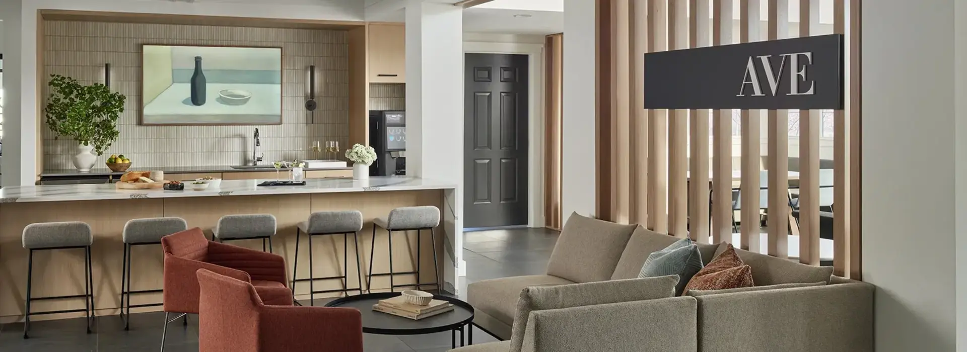 AVE Malvern lounge with a bar and barstools with a large AVE sign on the wall