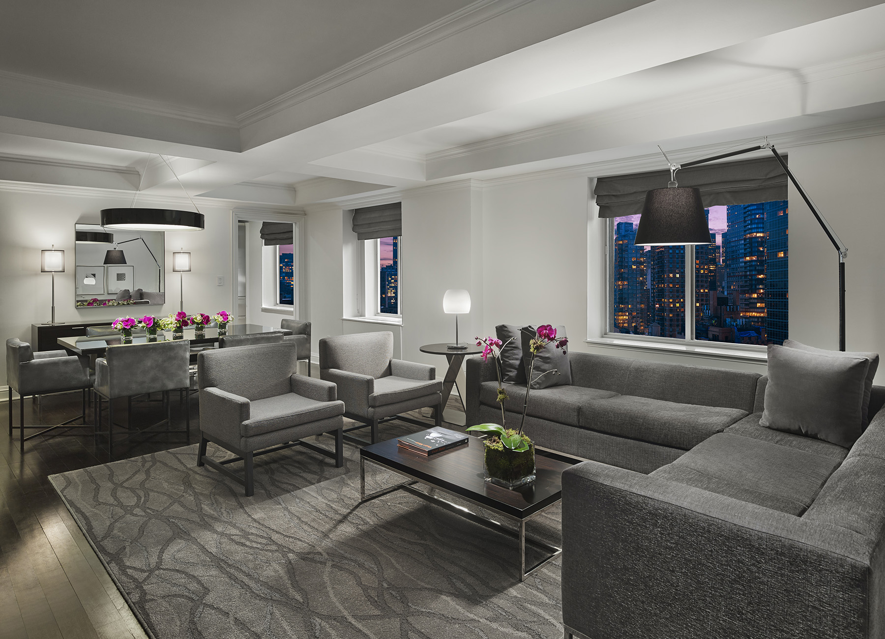 AKA Sutton Place furnished penthouse living room with gray couch and chairs on floor rug