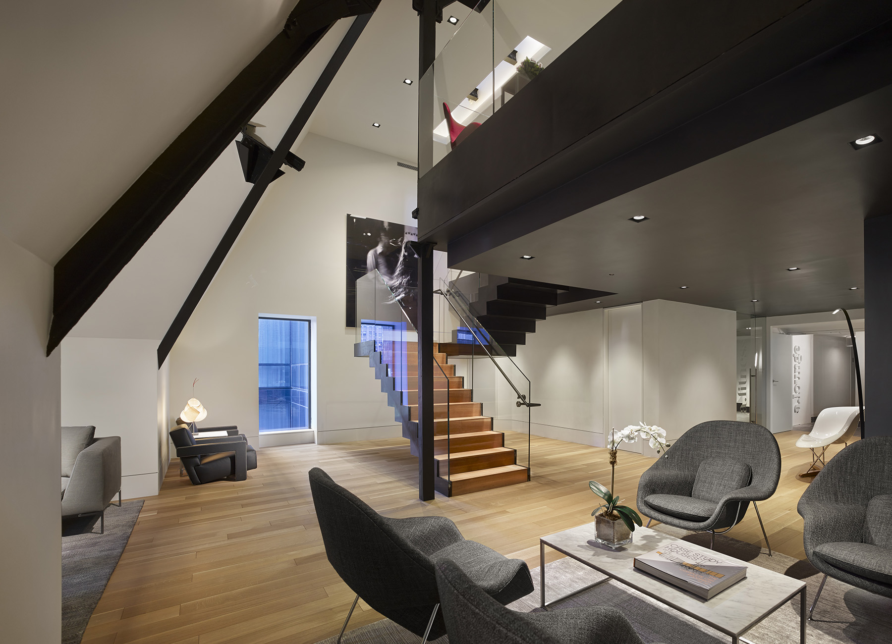 AKA Times Square penthouse lounge with seating options, open staircase, and wooden accents