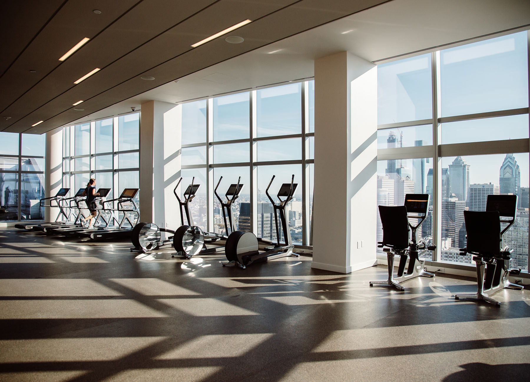 AKA University City fitness center with cardio equipment overlooking the Philadelphia skyline