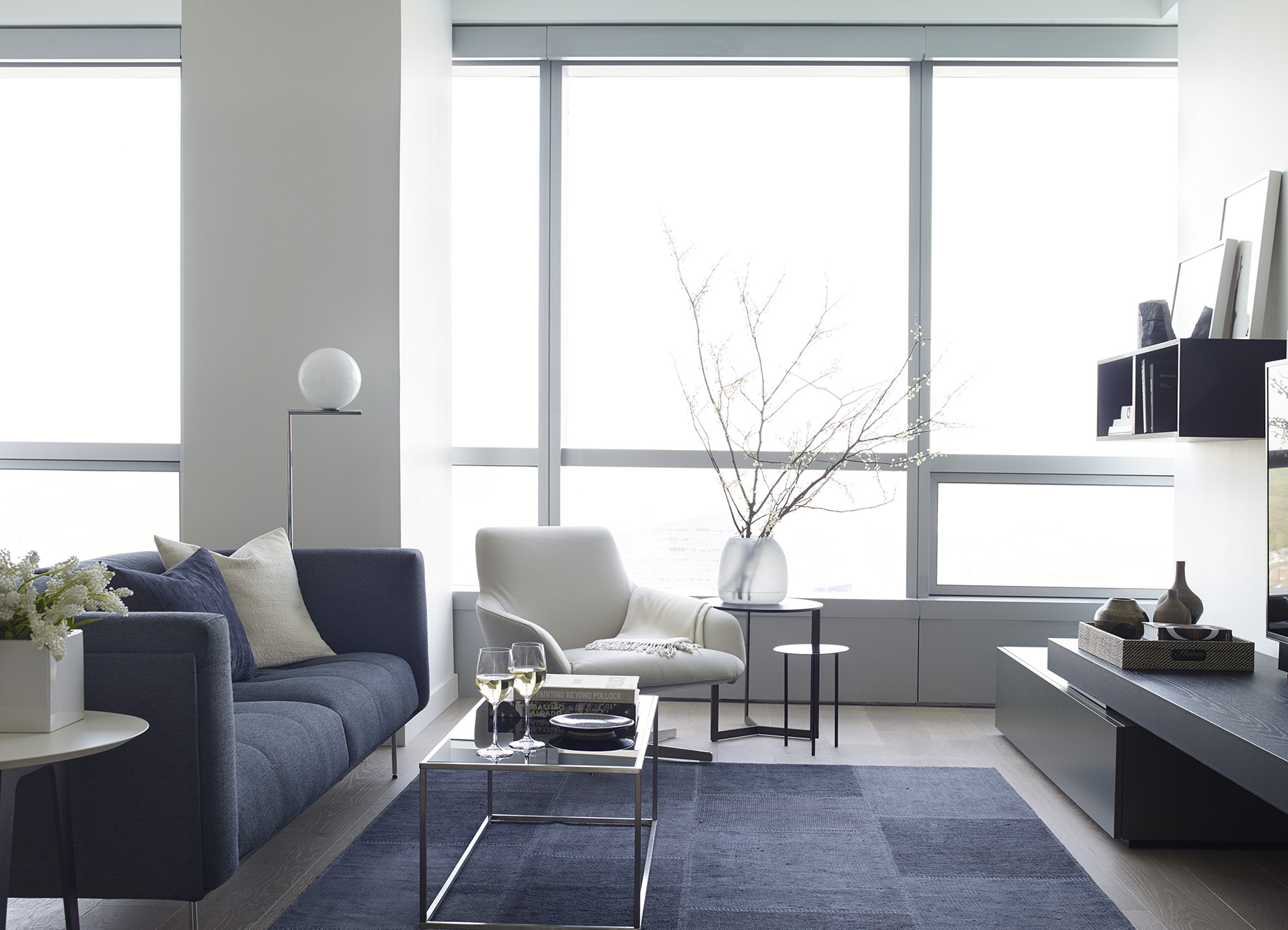 AKA University City living room with blue couch and Philadelphia city views through large windows 