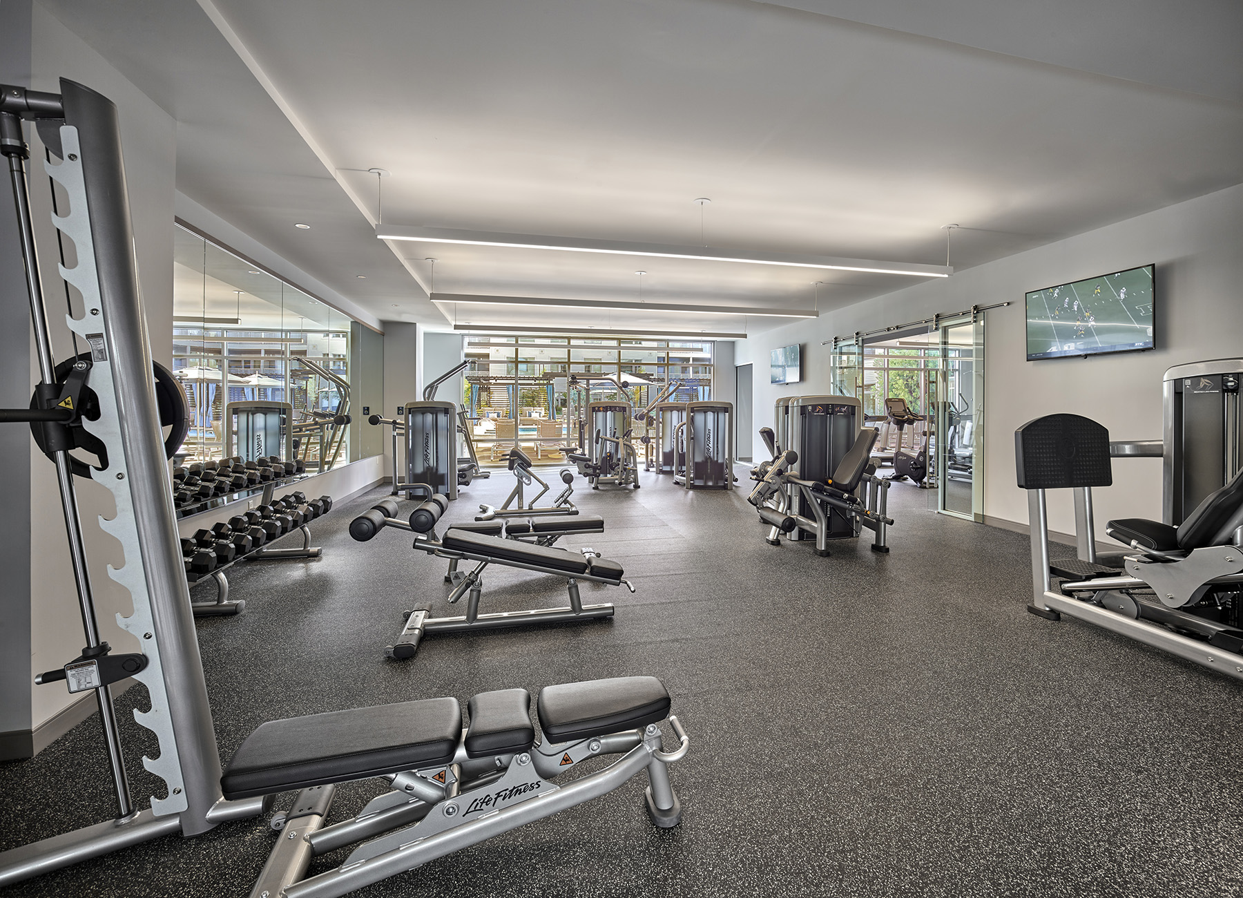 AVE Florham Park apartment community fitness center with large windows and strength equipment